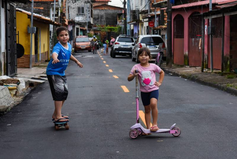 Crianças brincam com a rua asfaltada