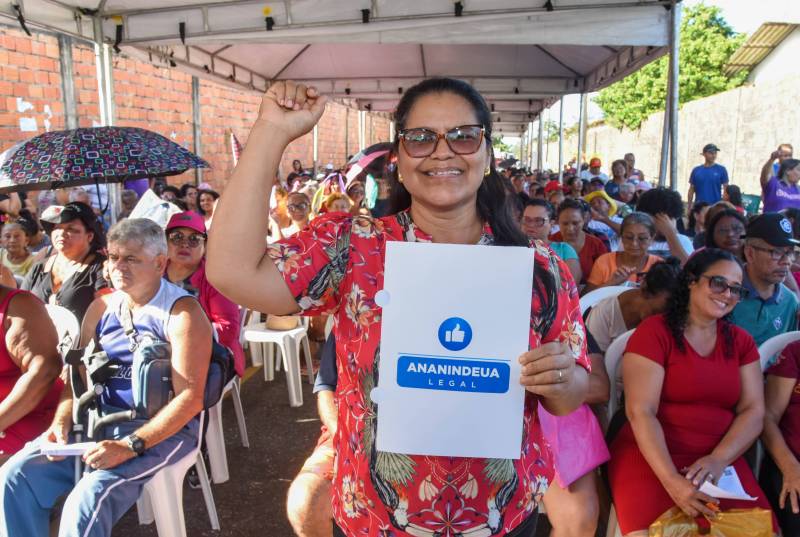 Moradora celebrando o sonho realizado, após receber a CRI da sua propriedade.